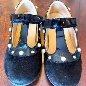 Little girls black Naturino shoes.